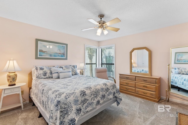 carpeted bedroom featuring baseboards, a textured ceiling, and a ceiling fan