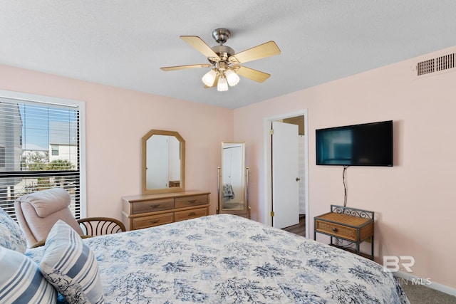 bedroom featuring baseboards, visible vents, carpet floors, and a textured ceiling