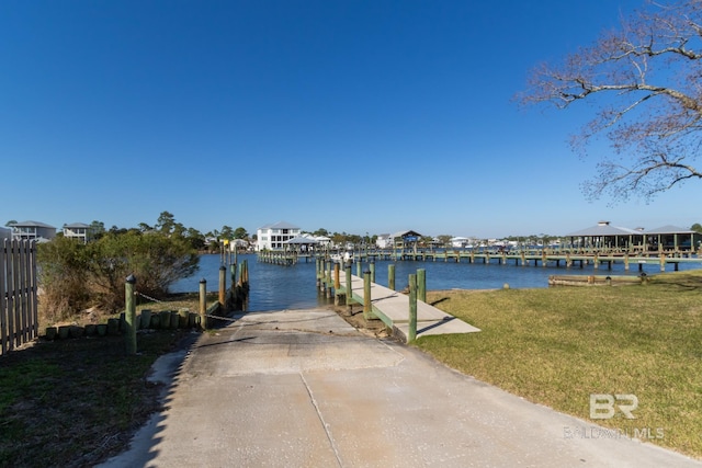 view of dock with a water view and a lawn