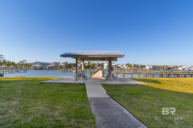 view of dock featuring a gazebo, a water view, and a lawn