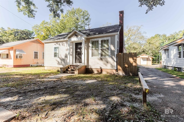 bungalow-style home with a storage shed and cooling unit