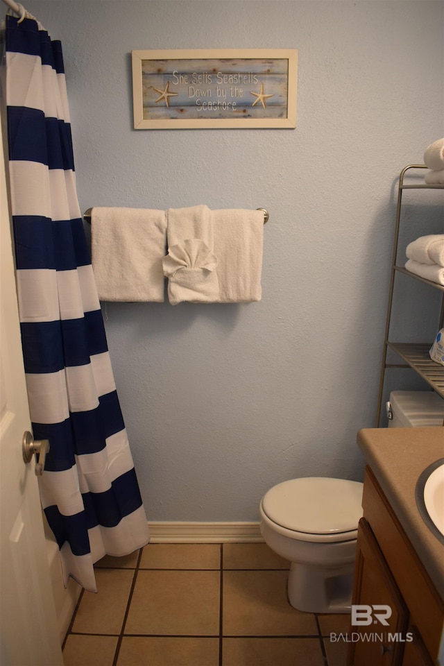 bathroom featuring curtained shower, tile patterned flooring, toilet, and vanity