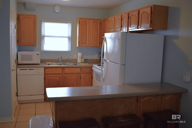 kitchen with white appliances, kitchen peninsula, light tile patterned flooring, and sink