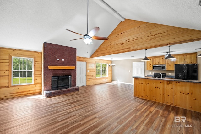 interior space featuring dark hardwood / wood-style flooring, ceiling fan, a brick fireplace, and plenty of natural light