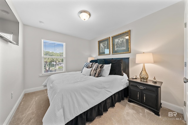 bedroom with light carpet and baseboards
