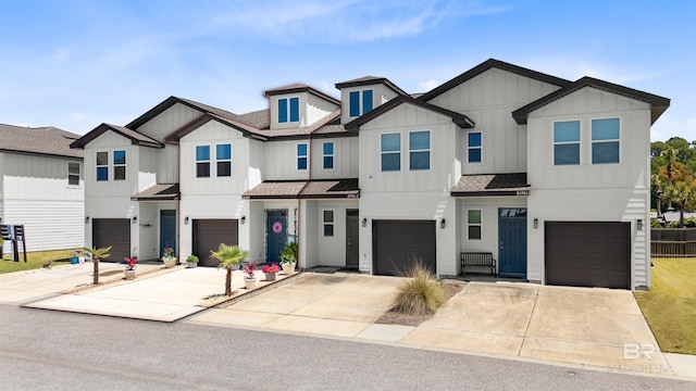 townhome / multi-family property featuring board and batten siding, an attached garage, a shingled roof, and driveway