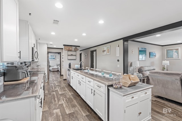 11691 Grantham Rd, Foley, AL 36535 - kitchen with appliances with stainless steel finishes, crown molding, white cabinets, dark wood-style floors, and open floor plan