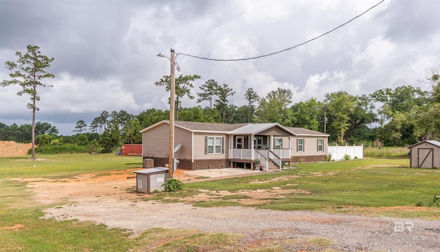 11691 Grantham Rd, Foley, AL 36535 - manufactured / mobile home with a shed, a front lawn, and view of wooded area