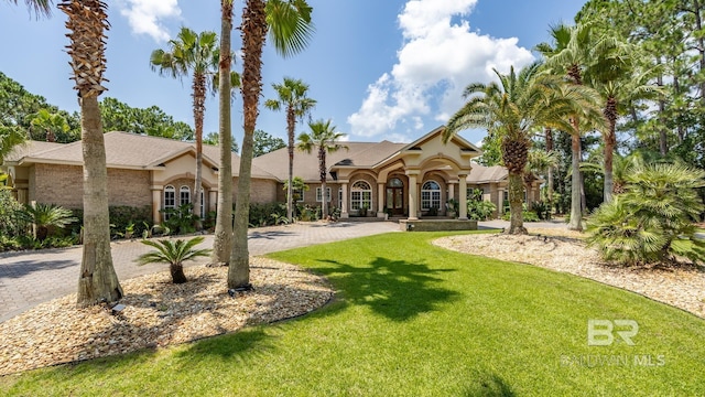 exterior space featuring a front lawn and decorative driveway