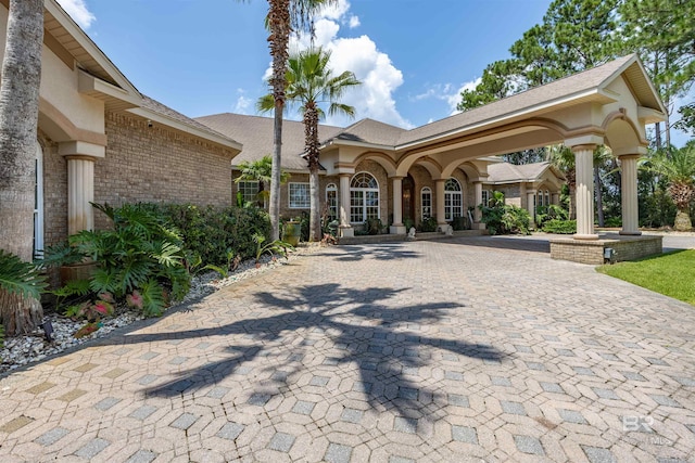 surrounding community featuring decorative driveway