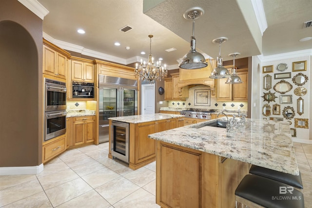 kitchen featuring pendant lighting, a large island, visible vents, appliances with stainless steel finishes, and beverage cooler