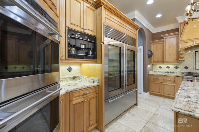 kitchen with stainless steel appliances, light tile patterned flooring, crown molding, and backsplash