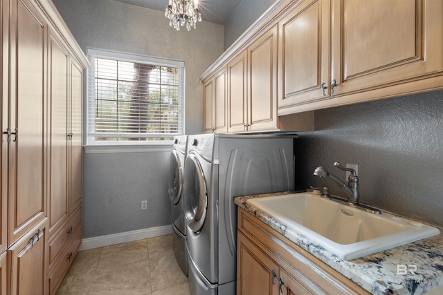 laundry room featuring light tile patterned floors, a sink, baseboards, cabinet space, and washing machine and clothes dryer