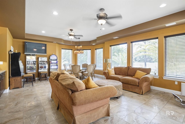 living area with ceiling fan with notable chandelier, recessed lighting, and baseboards