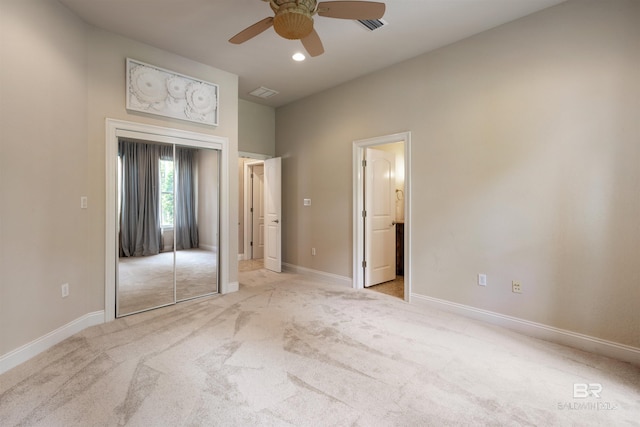 unfurnished bedroom featuring visible vents, baseboards, a closet, and light colored carpet