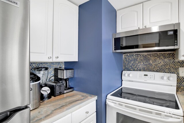 kitchen featuring decorative backsplash, white cabinetry, and stainless steel appliances