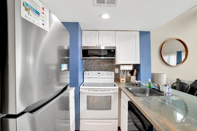 kitchen featuring appliances with stainless steel finishes, sink, decorative backsplash, and white cabinets