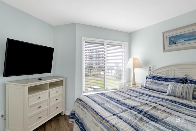 bedroom with baseboards and dark wood-style floors