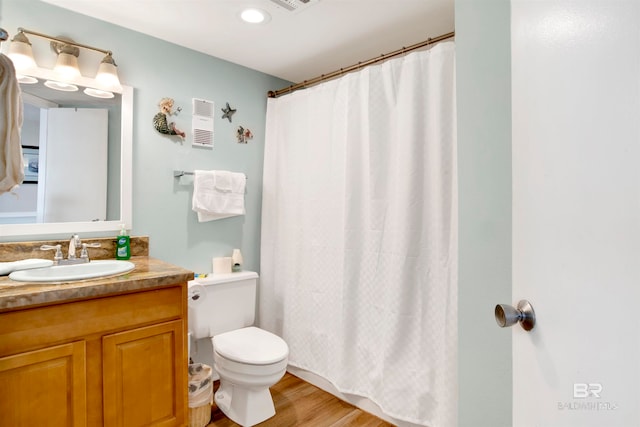 bathroom with vanity, hardwood / wood-style flooring, toilet, and walk in shower