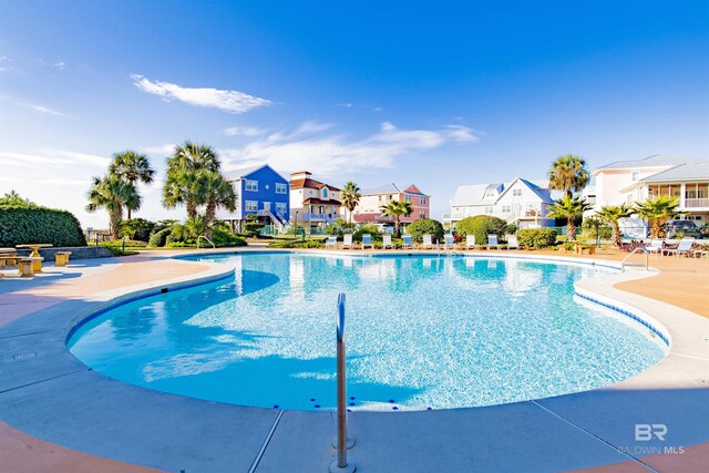 community pool featuring a patio and a residential view