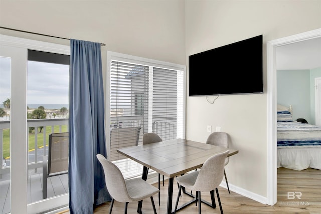 dining area with baseboards and light wood finished floors