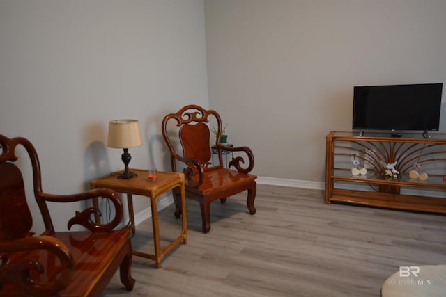 living area with wood finished floors and baseboards