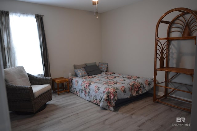 bedroom with multiple windows and wood finished floors