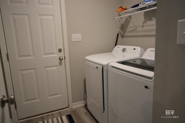 laundry room featuring laundry area, wood finished floors, and independent washer and dryer