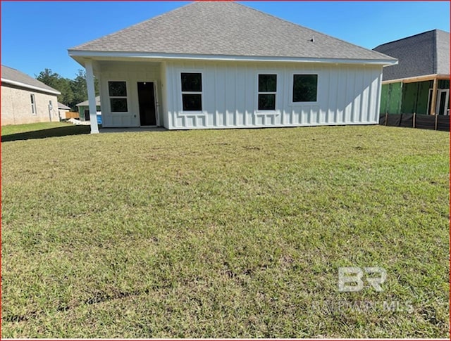 back of property featuring a lawn