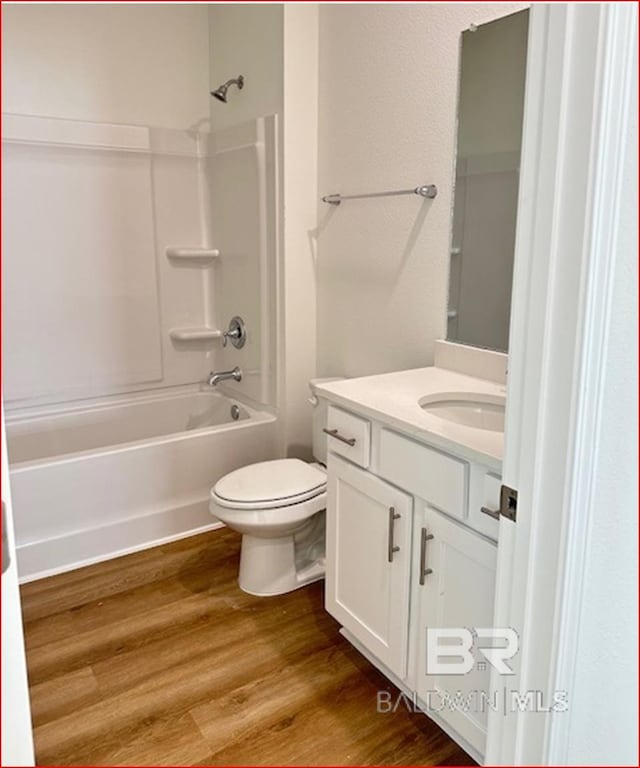 full bathroom featuring vanity, toilet, wood-type flooring, and bathtub / shower combination