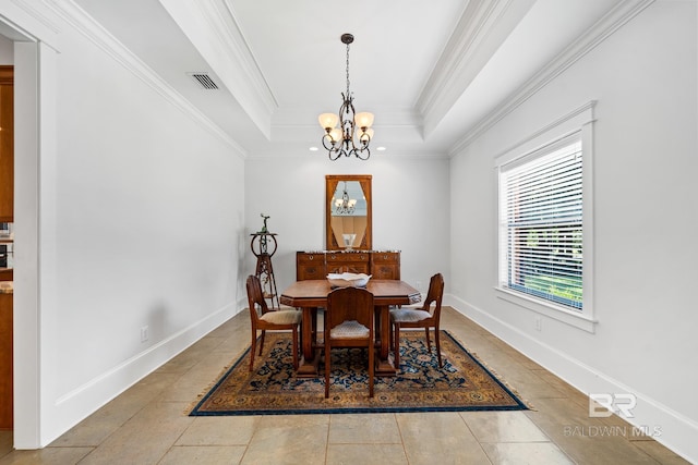 tiled dining room with a notable chandelier, ornamental molding, and a tray ceiling