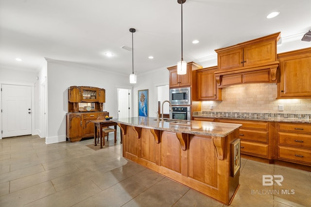 kitchen featuring a kitchen island with sink, a kitchen breakfast bar, ornamental molding, decorative light fixtures, and appliances with stainless steel finishes