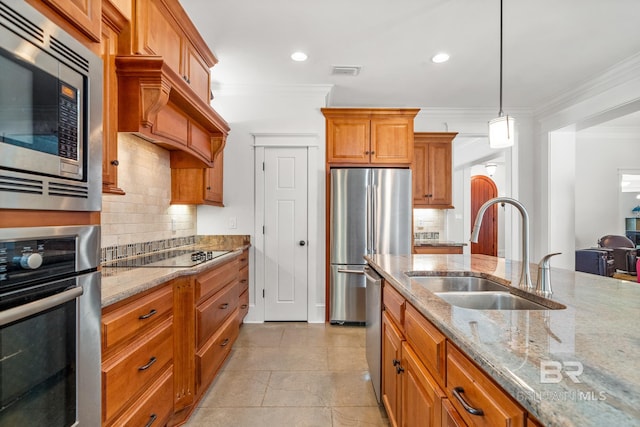 kitchen with light stone countertops, sink, pendant lighting, crown molding, and stainless steel appliances