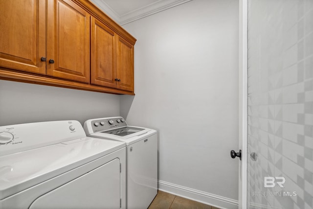 laundry area featuring dark tile patterned flooring, washer and dryer, ornamental molding, and cabinets