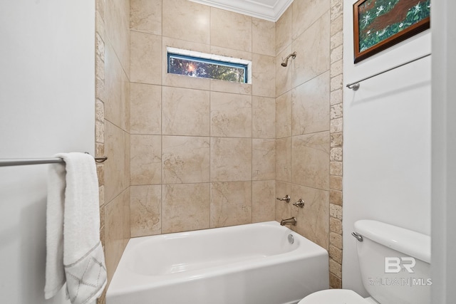 bathroom with toilet, crown molding, and tiled shower / bath combo