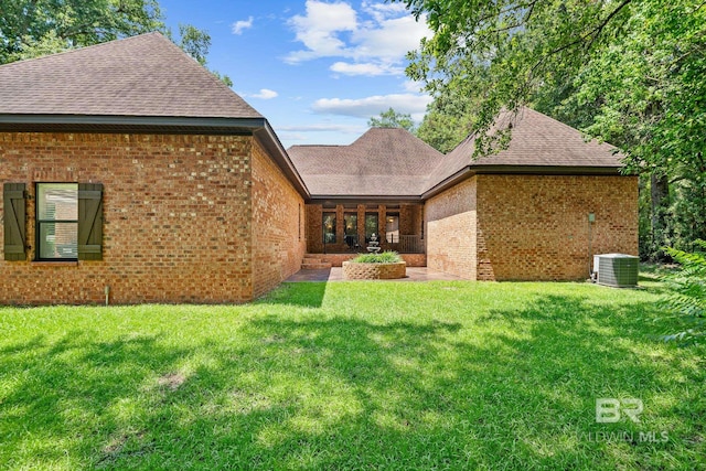 back of house with a lawn and cooling unit