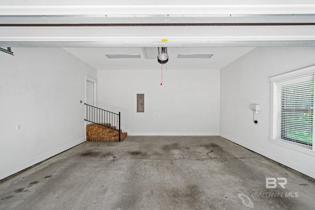 garage with a garage door opener and electric panel