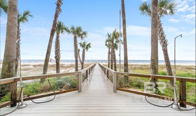 wooden terrace with a view of the beach and a water view