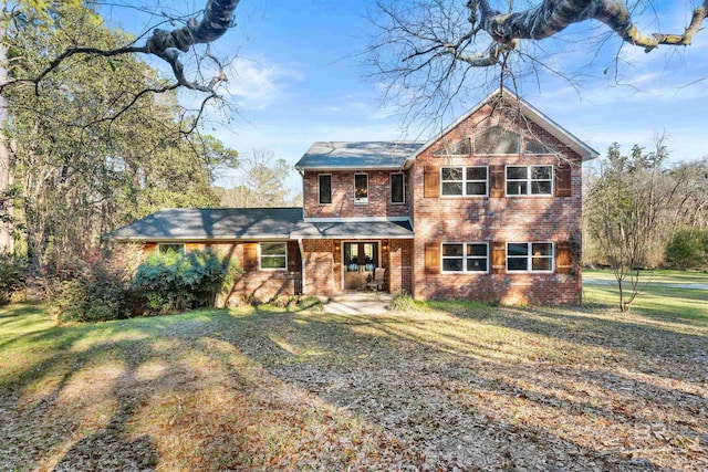 view of front of home with brick siding and a front yard