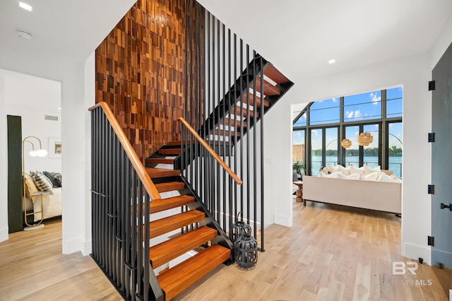 stairway featuring wood-type flooring and a water view