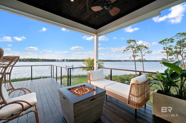 deck featuring an outdoor living space with a fire pit, ceiling fan, and a water view