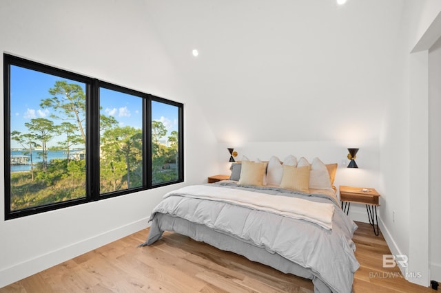 bedroom featuring lofted ceiling and light hardwood / wood-style flooring