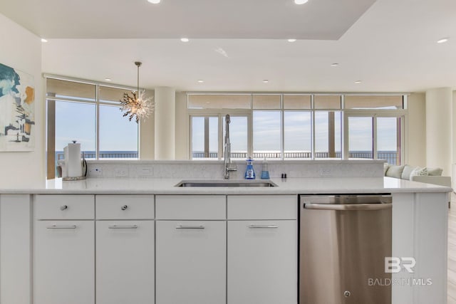 kitchen featuring decorative light fixtures, dishwasher, a wealth of natural light, and white cabinetry