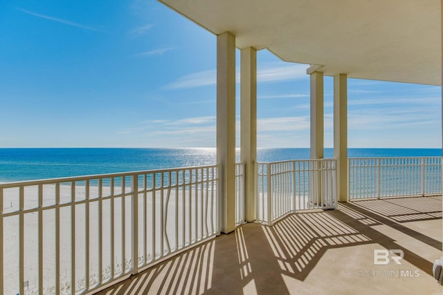 balcony featuring a water view and a beach view