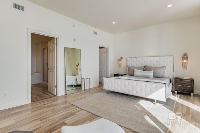 bedroom featuring light hardwood / wood-style flooring and ensuite bath