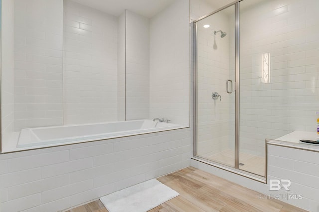 bathroom with plus walk in shower and hardwood / wood-style flooring