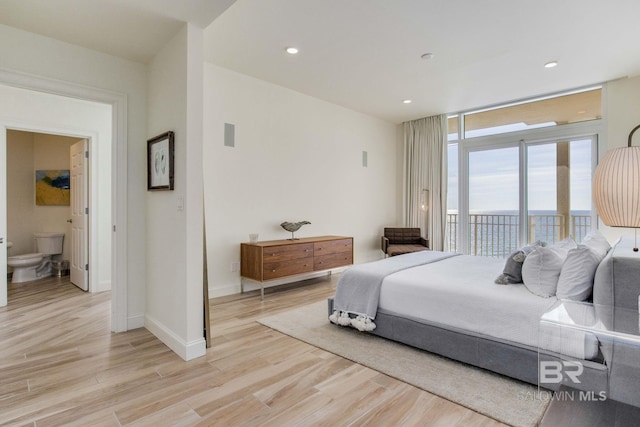 bedroom with access to outside, ensuite bath, and light hardwood / wood-style floors