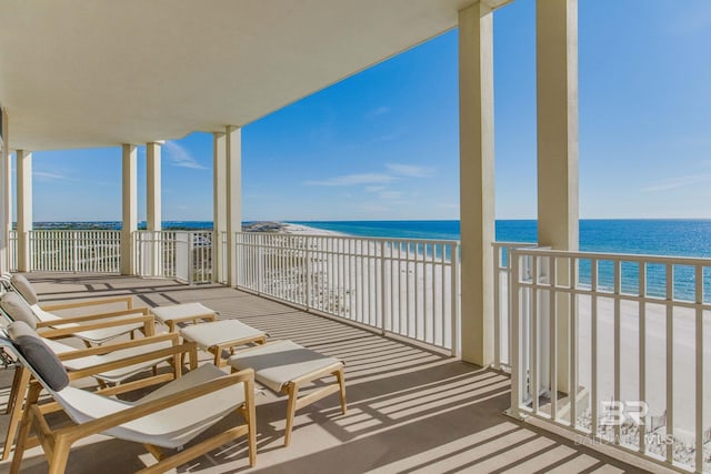 balcony featuring a view of the beach and a water view