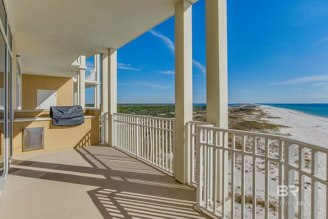 balcony featuring a view of the beach and a water view