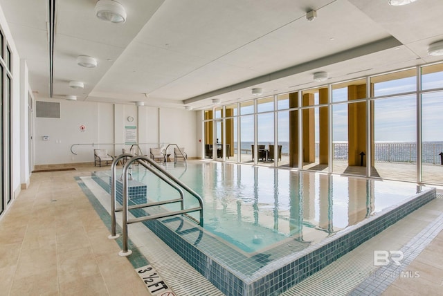 view of swimming pool featuring a water view and a jacuzzi